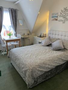 1 dormitorio con 1 cama grande, mesa y escritorio en The George Guest House en Bridlington