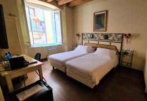 Postel nebo postele na pokoji v ubytování Hotel Piazza Vecchia