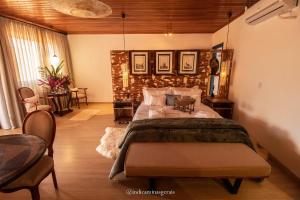 a bedroom with a bed and a table and chairs at Pousada Quatro Estações in Bichinho +139 photos