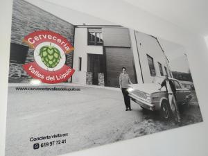 mężczyzna stojący obok samochodu przed garażem w obiekcie Edificio Valles del Lúpulo (DUPLEX) w mieście Astorga