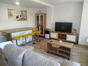 a living room with a couch and a flat screen tv at Edificio Valles del Lúpulo (DUPLEX) in Astorga