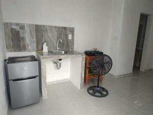 - une cuisine avec un évier et un ventilateur dans la chambre dans l'établissement Departamento sencillo en CAMPECHE EX HACIENDA KALA, à Campeche