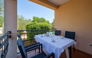 a table with a white table cloth on a balcony at Villa Franka 113 in Bašanija