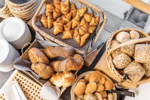 un mucchio di diversi tipi di pane in cesti di Hotel Alpensonne - Panoramazimmer & Restaurant a Arosa