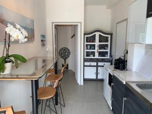 eine Küche mit einer Theke und 2 Hockern in der Unterkunft La Maison du Cotton- Gite bio-climatique in Andernos-les-Bains