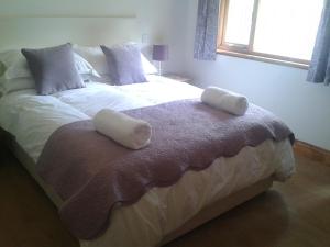 a bedroom with a large bed with two pillows on it at Manor Garden Lodge in Wirral