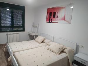 sypialnia z łóżkiem i poduszkami w obiekcie Edificio Valles del Lúpulo (DUPLEX) w mieście Astorga