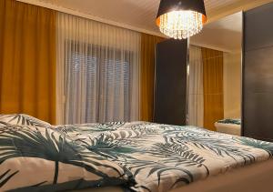 sypialnia z łóżkiem i żyrandolem w obiekcie Apartments Fiore am Naturschwimmbad! w mieście Puch