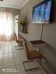 a living room with a tv and a table and chairs at Atholl Heights Home in Westville