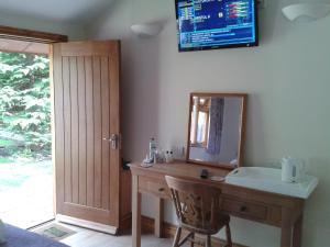 a bathroom with a sink and a mirror on the wall at Manor Garden Lodge in Wirral