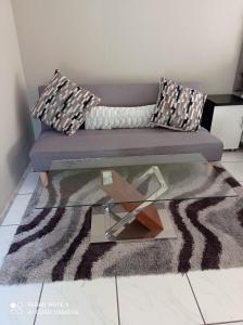 a living room with a couch and a glass table at Atholl Heights Home in Westville