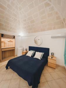 1 dormitorio con 1 cama grande con manta azul en B&B Stellamarina, en Pulsano