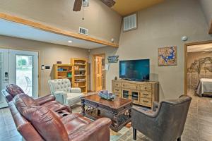 a living room with a leather couch and a television at Lake Texoma Cabin - 1 Mi to Park and Boat Ramp! in Willow Spring