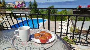 a plate of muffins and a cup of coffee on a table at Villa Sv Stefan in Ohrid