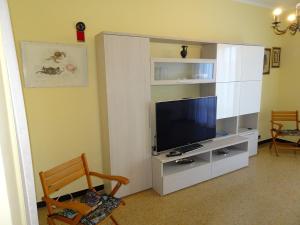 a living room with a television on a white entertainment center at DaVinci104 in Alassio