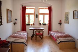 een kamer met 2 bedden, een tafel en een raam bij Rychta in Rataje nad Sázavou