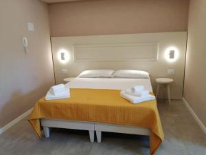 a bedroom with a bed with two towels on it at Loris House in Tropea