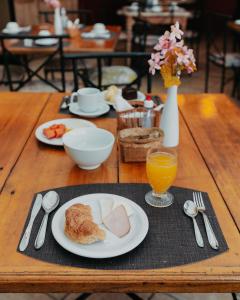 una mesa con platos de comida y un vaso de zumo de naranja en Kastel Itaipava, en Itaipava