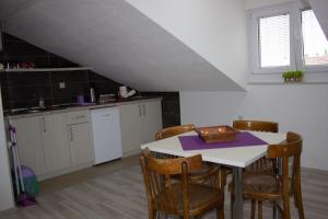 - une cuisine avec une table et des chaises dans la chambre dans l'établissement Markulev Apartment, à Ohrid
