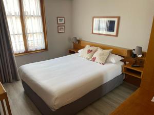 a bedroom with a large white bed with two pillows at Hôtel Sainte Odile in Obernai