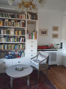 a room with a table and a book shelf with books at La Romantique in Paris