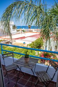un tavolo e sedie su un balcone con palma di H El Palmeral Playa a Mojácar