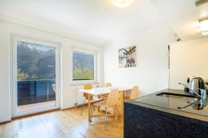 uma cozinha e sala de jantar com uma mesa e janelas em Grenzberg - Bad Gastein em Bad Gastein