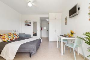 ein Schlafzimmer mit einem Bett, einem Tisch und einem Schreibtisch in der Unterkunft SWEET DREAMS BENALBEACH in Benalmádena