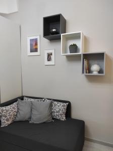 un divano nero in un soggiorno con scaffali di Apartment Casa Felice a Ostuni