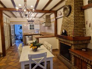 Un comedor con mesa y chimenea. en VACACIONES DE LUJO.CHALET PISCINA Y PLAYA.EL PUERTO, en El Puerto de Santa María