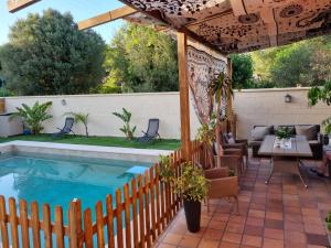 un patio con piscina y una valla de madera en VACACIONES DE LUJO.CHALET PISCINA Y PLAYA.EL PUERTO, en El Puerto de Santa María