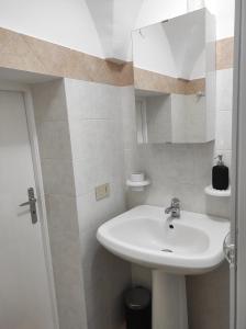 uma casa de banho com um lavatório branco e um espelho. em Apartment Casa Felice em Ostuni