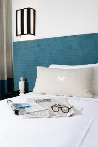 a bed with a magazine and a pair of glasses on it at Villa delle Palme in Santa Marinella