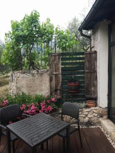 Ofena的住宿－Al Casolare，庭院里种着鲜花,配有木桌和椅子