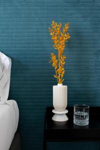 a white vase with a plant in it on a table at Villa delle Palme in Santa Marinella