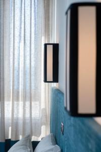 a room with a bed with a lamp and a window at Villa delle Palme in Santa Marinella
