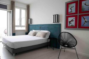 a bedroom with a bed and a chair in it at Villa delle Palme in Santa Marinella