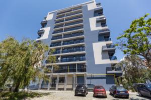 un edificio con coches estacionados frente a él en Central Beach, en Mamaia