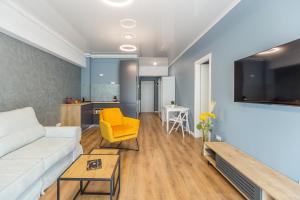 a living room with a white couch and a yellow chair at Central Beach in Mamaia