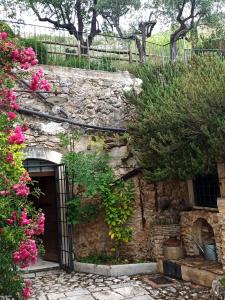 a stone building with a door and some flowers at Al Casolare in Ofena
