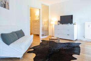 巴德加斯坦的住宿－Grenzberg - Bad Gastein，客厅配有白色沙发和电视