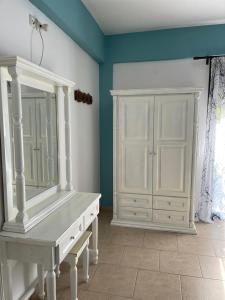 a room with a white dresser and a mirror at Villa Georgia in Pitsidia