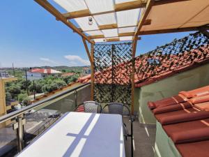 a balcony with a table and chairs on a roof at Apartments Kidonis in Limenaria