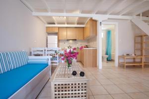 a living room with a couch and a table with flowers at Central Studios in Agios Nikitas pedestrian zone in Agios Nikitas