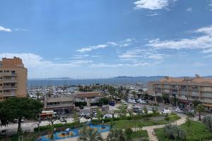 a city with buildings and a parking lot with cars at L'EFFET MER, DUPLEX SUR LE PORT AVEC SES 2 TERRASSES VUE MER in Hyères