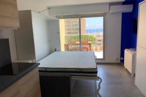 a bed in a room with a large window at L'EFFET MER, DUPLEX SUR LE PORT AVEC SES 2 TERRASSES VUE MER in Hyères