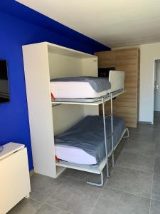 two bunk beds in a room with a blue wall at L'EFFET MER, DUPLEX SUR LE PORT AVEC SES 2 TERRASSES VUE MER in Hyères