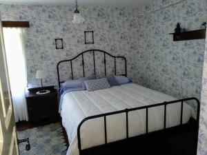 列加內斯的住宿－La Costera en Liérganes, Cabarceno，卧室内的一张床铺,配有蓝色和白色的壁纸
