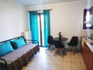 a living room with a couch and a table with chairs at Avra Studios in Kymi