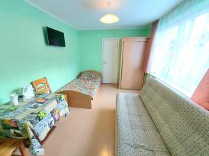 a room with two beds and a couch and a window at Neringos 8 in Palanga